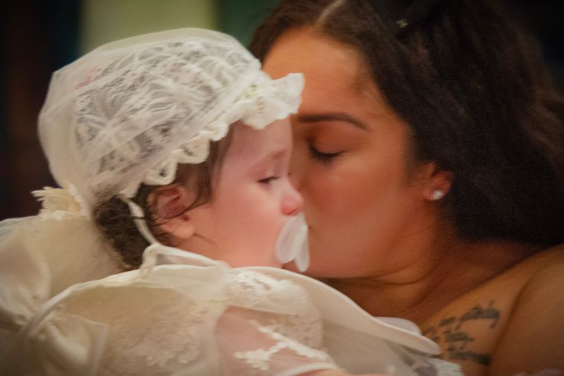 Christening day — a kiss for the guest of honor