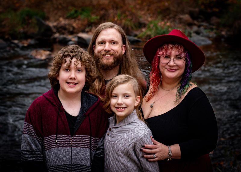 Family portrait by the creek under the covered bridge